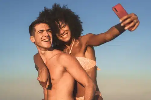 multicultural couple on vacation taking selfies on 2023 11 27 05 15 25 utc